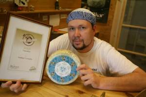 Egil Smith Meyer med et eksemplar av osten og diplomet som beviser at den lille lokale osteprodusenten i Tingvoll fikk gullmedalje I 2011 under verdens største ostefestival International Cheese Awards i Storbritannia. Kraftkaren vann i kategorien for beste kumjølksbaserte blåmuggost laga utanfor Storbritannia. (foto: Arne Storrønningen)